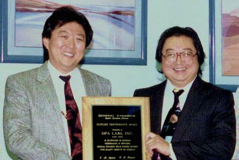 Two men holding an award plaque.