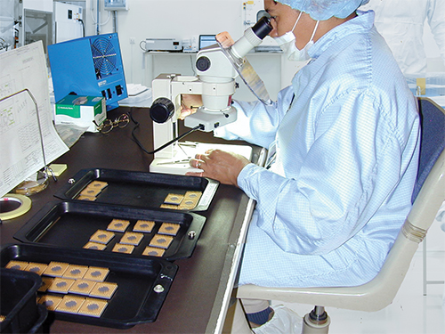 a person inspecting a chip under the Microscope